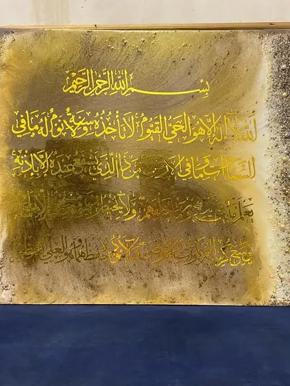 This large Ayat al-Kursi artwork features a brown and gold color scheme with heavily textured borders, making it a statement piece for a living room.