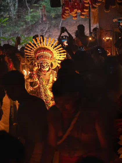 A series showing the Karim Gullikan Theyyam performance, surrounded by devotees and fire. These images document the energy of the crowd and the deity's commanding presence during the ritual.