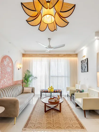 This cozy living room features custom wall mural arches and a beautiful cane ceiling light, which adds a touch of warmth and natural elegance.