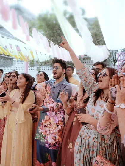 The guests' reactions say it all. A shot of the cheering crowd, fully immersed in the energy and excitement of the Haldi celebration.