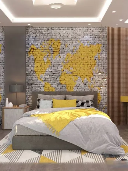 A cool and edgy bedroom for a teenager, featuring a brick wall with a yellow world map graffiti design. The integrated desk and open shelving provide a functional study and display area.