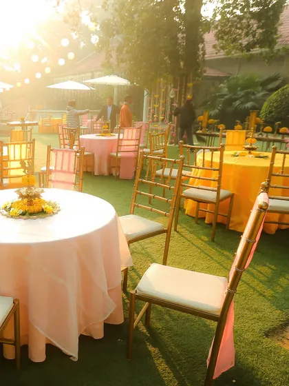 The lawn seating in the soft morning light, with pink and yellow table settings, ready for a brunch or lunch event.