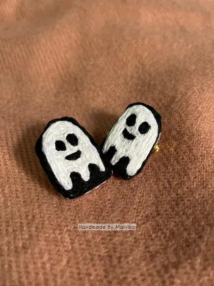 A closer look at the two friendly ghost badges. Each one is stitched by hand, so they have their own slightly different, quirky personalities. They are a simple and fun piece of wearable art.