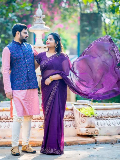 A dynamic shot capturing the movement of the bride's saree near a garden fountain.