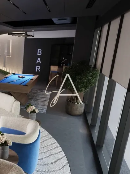 The lounge area of the wellness center, featuring a pool table and comfortable seating. Large windows provide ample natural light, while the modern furniture and 'BAR' sign create a relaxed, club-like vibe.