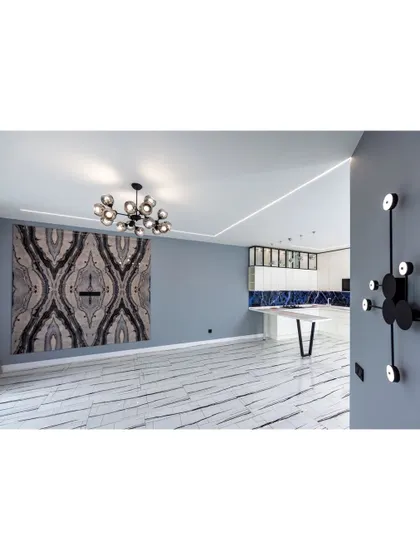 A space that showcases bold design choices. The large, abstract tapestry and unique wall-mounted light fixture act as functional art, adding personality to this modern interior.