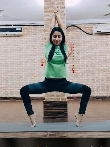 A member showing great form and balance in the Utkata Konasana, or Goddess Pose, on her toes. This pose is amazing for toning the inner thighs and glutes.