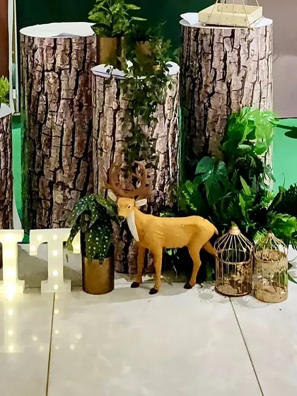 Detail shot of the log-print plinths, marquee letters, and small deer prop, showing the layers of the jungle decor.