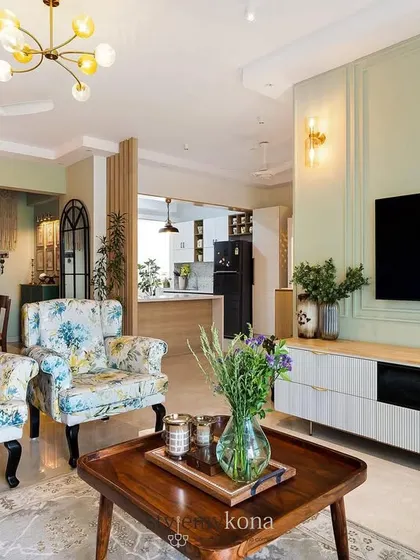 Another angle of the sage green living room, showing how the printed armchairs and wooden TV console complement the wall color beautifully.