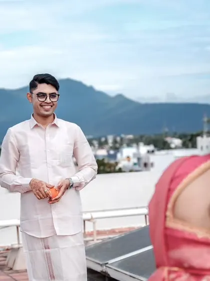 A candid "first look" moment on the rooftop, capturing the groom's happy expression.