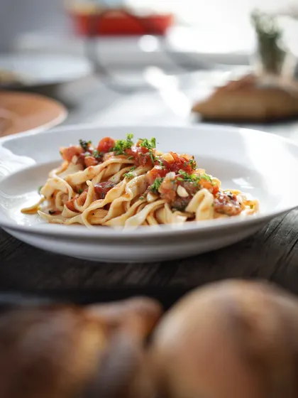 A beautifully plated dish of tagliatelle with a fresh tomato sauce. This is the delicious result of our hands-on pasta making sessions.