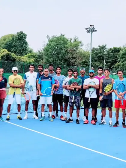 We are a team, a family. This is a glimpse of our entire group of dedicated male and female players and coaches, standing together on our blue hard court, ready for another day of rigorous training.
