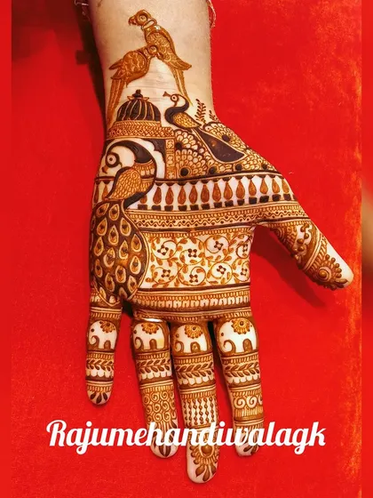 A beautiful design for the back of the hand, featuring a peacock and parrots. The fingers are decorated with elephant motifs.