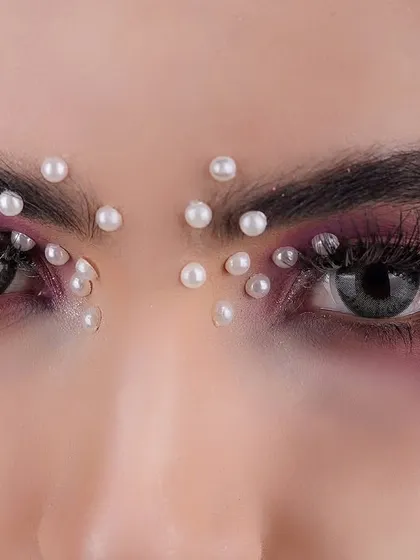 It's all in the details. For artistic beauty close-ups, we can experiment with creative makeup like these floral and pearl accents to create an enchanting and memorable portrait.