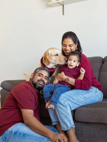Sometimes the most beautiful moments happen right on your own sofa. This at-home lifestyle session shows a family in their happy place, with their Labrador giving the newest little member a gentle welcome lick. It’s authentic, comfortable, and so full of love.