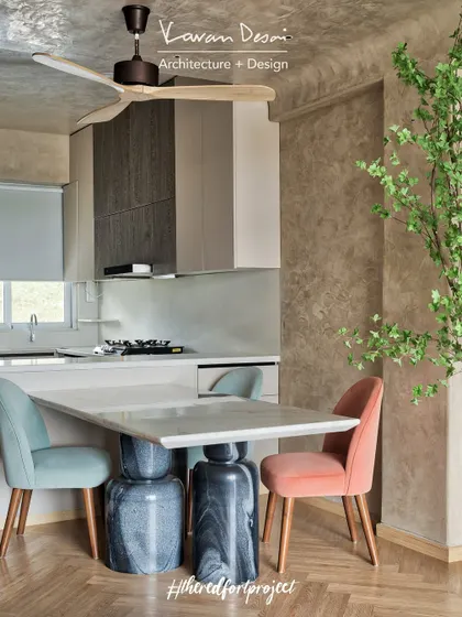 A close-up of the dining area in the "RED Fort Project." The custom table features two solid marble blocks as its base, paired with chairs in soft, contrasting colors for a playful touch.