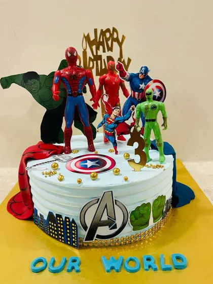 A side view of the action-packed Avengers cake, showing the detailed character figures and the iconic Avengers logo.