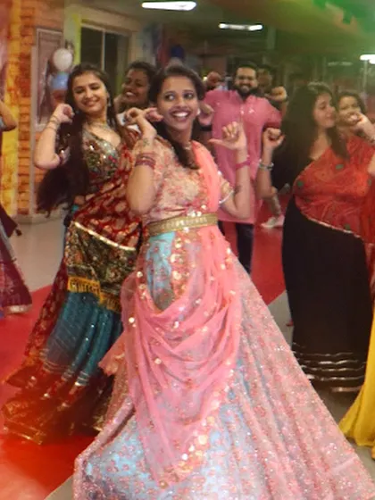 A participant in a beautiful lehenga enjoying the dance. I encourage everyone to dress up and fully immerse themselves in the festive experience.