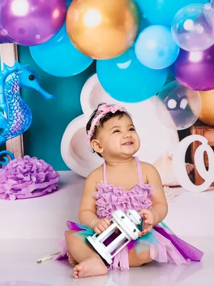 Looking up with a happy gaze, this little mermaid is enjoying her time in our enchanting underwater studio setup.