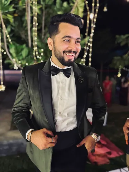 A candid, happy shot in a classic black tuxedo at a reception. A timeless look for a timeless celebration, ready to hit the dance floor.
