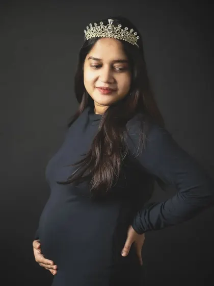 A close-up portrait capturing the serene expression of a mom-to-be wearing a crown. It's a beautiful shot that highlights the feeling of motherhood.
