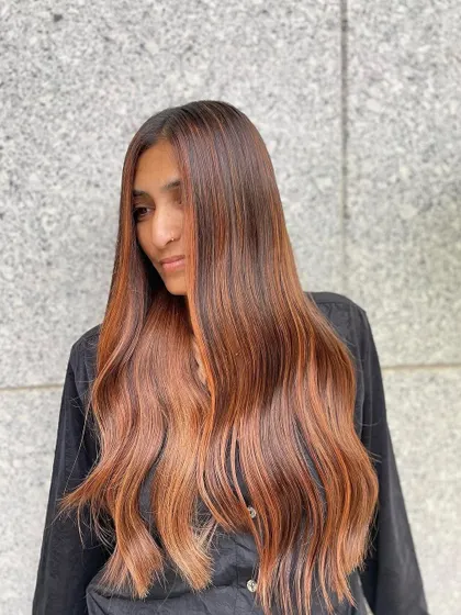 A profile shot of the copper balayage, showing the seamless blend from the natural root into the vibrant lengths.