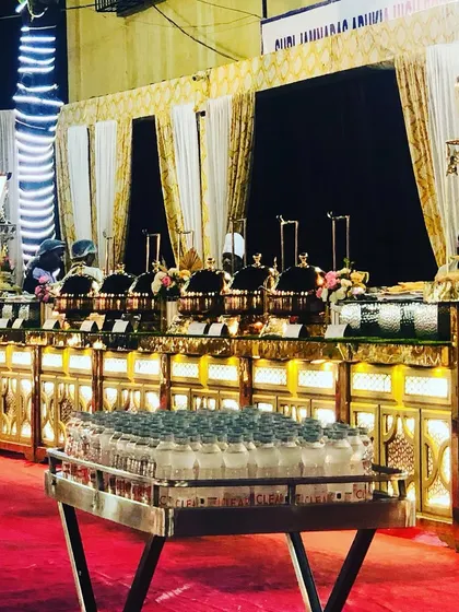 A complete view of the main course buffet line for an engagement. The setup includes neatly arranged chafing dishes and a dedicated station for bottled water, ensuring a seamless experience.