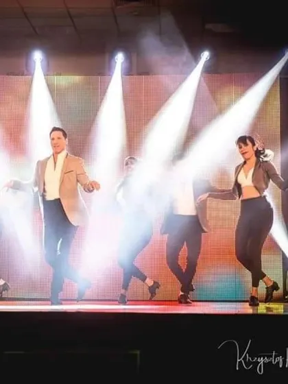 The magic of stage lighting. A well-lit performance can transform the entire mood. Here, the Motley Crew performs a group number, using spotlights to create a dramatic and professional effect.