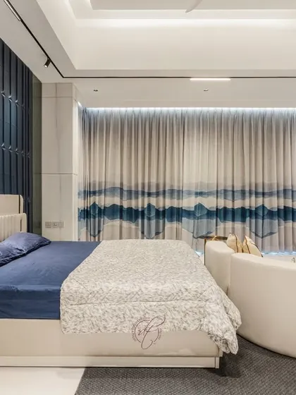 This shot focuses on the bed and the dramatic blue accent wall, with the elegant curtains creating a soft, flowing backdrop. It’s a perfect example of a modern, stylish sanctuary.