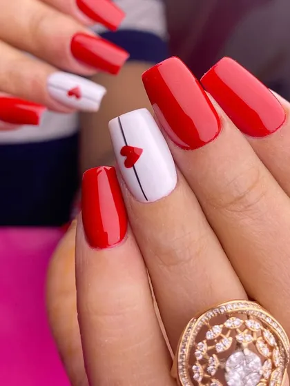 A simple and sweet Valentine's look. This set features classic red nails with a white accent nail that has a tiny, minimalist heart.