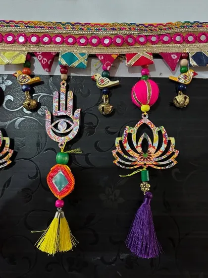 Detail of the 'Shubh Toran', focusing on the colorful tassels and fabric-wrapped beads. Each tassel is handmade and chosen to complement the colors in the main design.