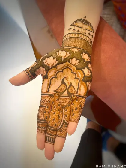 A beautiful design combining two peacocks on the palm with a lotus jaal pattern on the wrist. The negative space makes the figures pop.