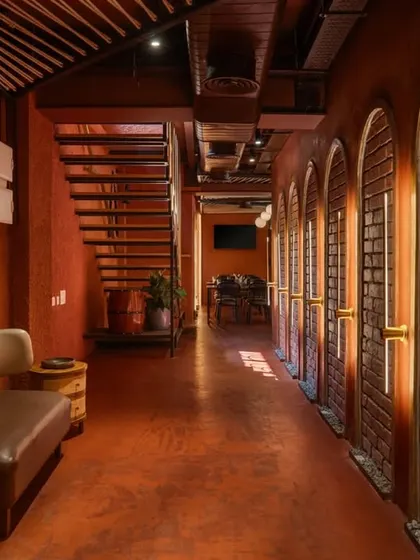 Natural light filters into the corridor, highlighting the texture of the brickwork and the simple, modern bench. The artwork adds a splash of color and personality to the passage.