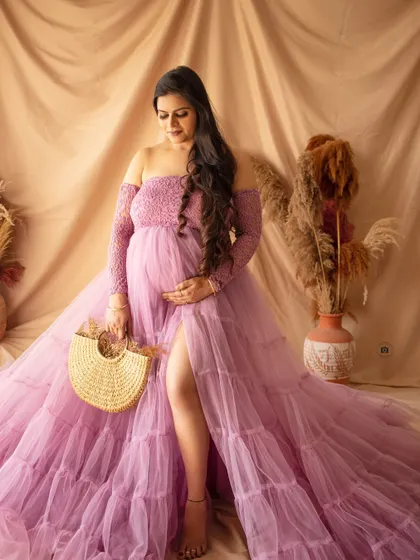 A stylish portrait featuring a lavender off-the-shoulder gown and a chic straw bag, blending glamour with a touch of boho.
