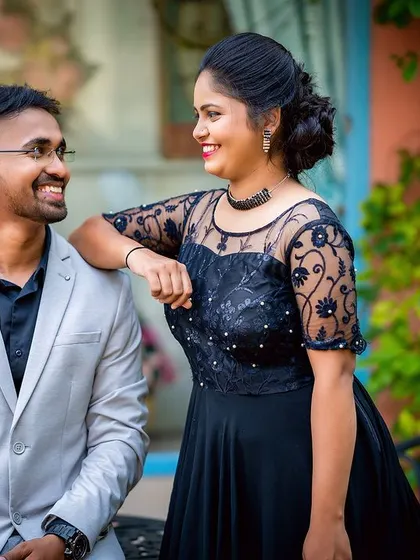 A relaxed and cheerful portrait of a couple sharing a smile, captured in a charming outdoor cafe setting.