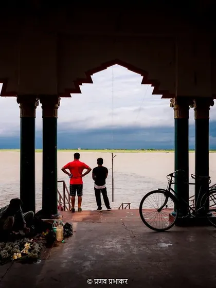 My street photography often involves finding frames within frames. Here, the pillars of the ghat create a natural frame for the two figures looking out at the water, telling a quiet story of contemplation.