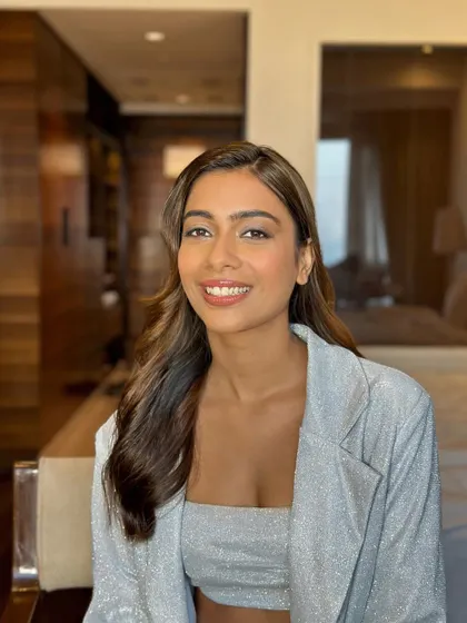 A happy client in her hotel room, ready for her event with flawless makeup and beautifully styled waves.