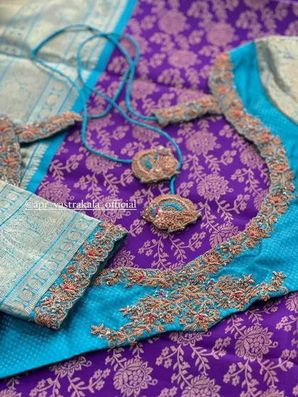 A turquoise and purple blouse with delicate embroidery and tassels.