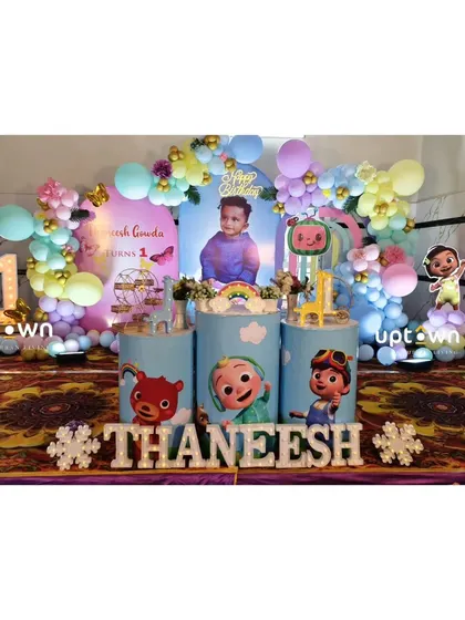 A Cocomelon themed first birthday with custom pedestals and a pastel balloon arrangement.