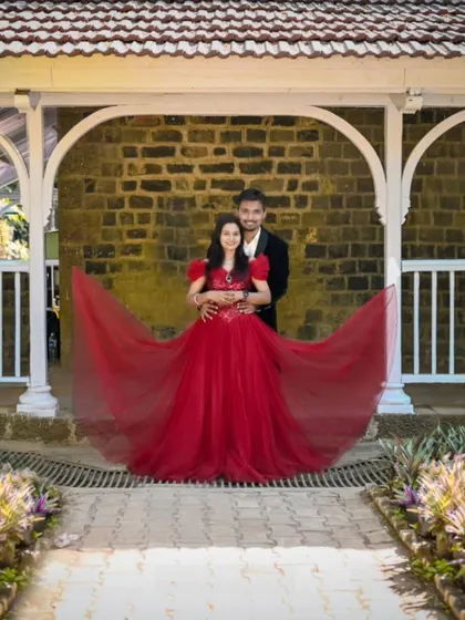 A perfectly framed couple portrait. The bride's red ball gown with its puffed sleeves and sequined bodice creates a romantic and timeless look.