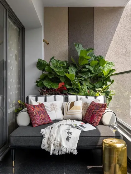 A cozy daybed we created for a balcony space, featured in an Architectural Digest article. The piece is styled with numerous cushions, creating an inviting outdoor relaxation spot.