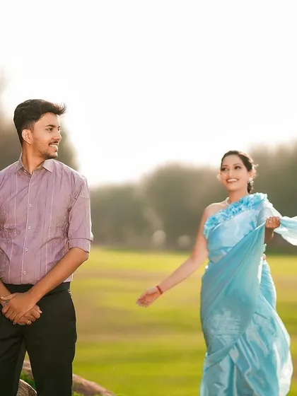 A playful and breezy outdoor shot, with the bride's light blue saree catching the wind beautifully.