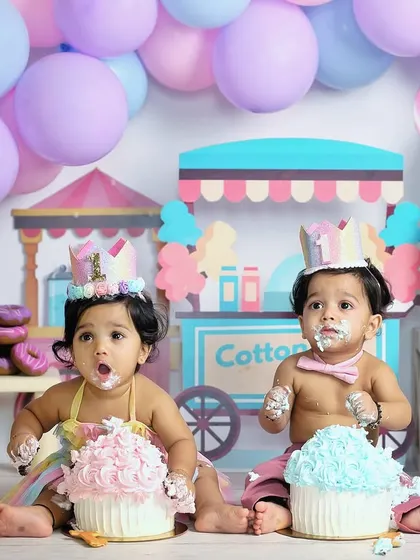 A candid moment from a twin cake smash session. With cake on their faces and hands, these two are having the best time celebrating their first birthday together.
