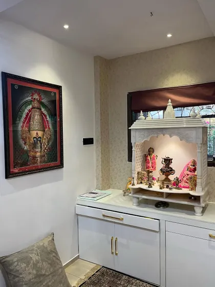 A beautiful home mandir I designed and installed. This piece combines a classic white marble temple with modern, high-gloss white cabinetry for storage, complete with elegant gold handles and dedicated overhead lighting to create a peaceful, sacred space.
