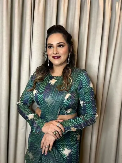 A sophisticated look for a wedding guest. The makeup is glamorous with a bold lip, and the printed saree adds a modern, fashionable touch.