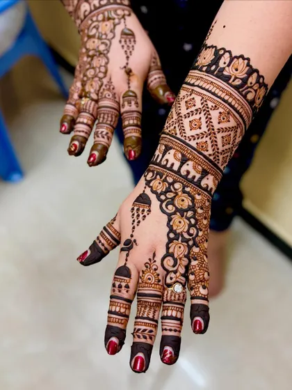 An angled view of Shubha's celebratory mehendi, showing the jhumka and elephant motifs.