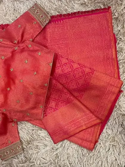 The front of the pink blouse, showing the simple boat neck and embroidered sleeves.
