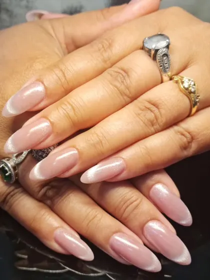 A soft and elegant manicure with a sheer, shimmery polish and a subtle white tip.