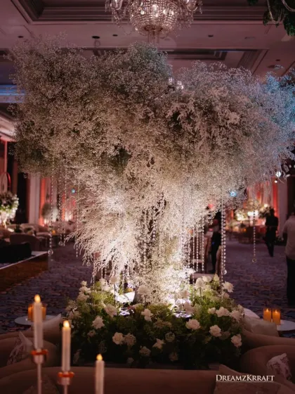 The iconic floral tree, reimagined with a cloud of baby's breath and sparkling crystal strings. This centerpiece was a consistent visual element, tying the different functions of the wedding together.