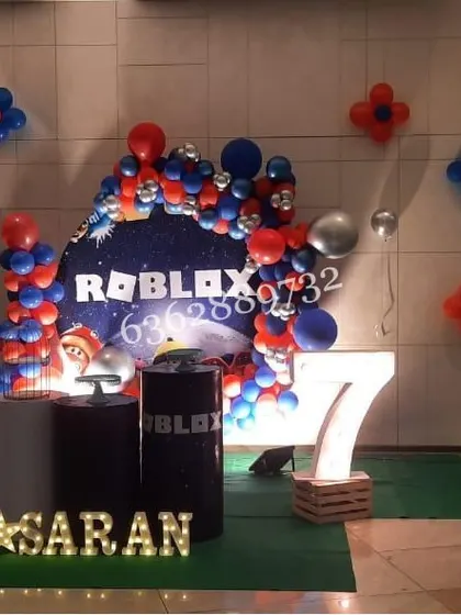 Powering up for a Roblox themed 7th birthday party, with a custom backdrop, themed cake stands, and marquee letters.